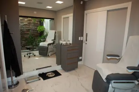 Sala de consulta moderna en la clínica Dr. Mario Bongiolo con sillón médico y vista al jardín