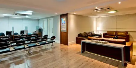 Área de espera moderna en la clínica Colonetti con asientos cómodos y recepción