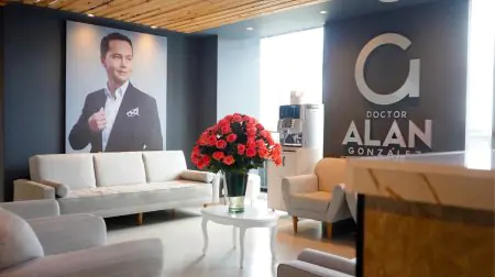 غرفة انتظار حديثة في عيادة Alan Gonzalez 360 Plastic Surgery مع أرائك وزهور