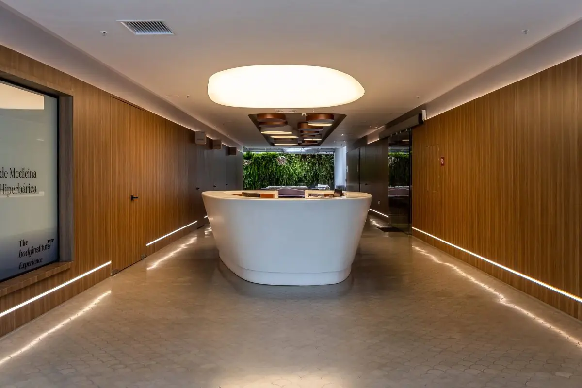 Reception desk at AmayaClinic® with modern wood interior and ambient lighting