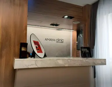 Mostrador de recepción en AmayaClinic con encimera de mármol y logotipo de la clínica