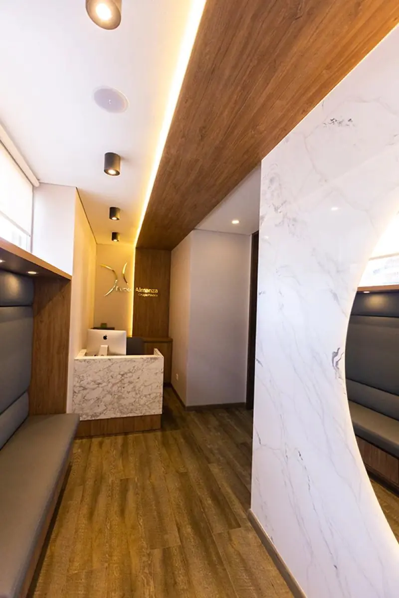 Reception area at Dr. Ruber Almanza Clinic with modern marble and wood design