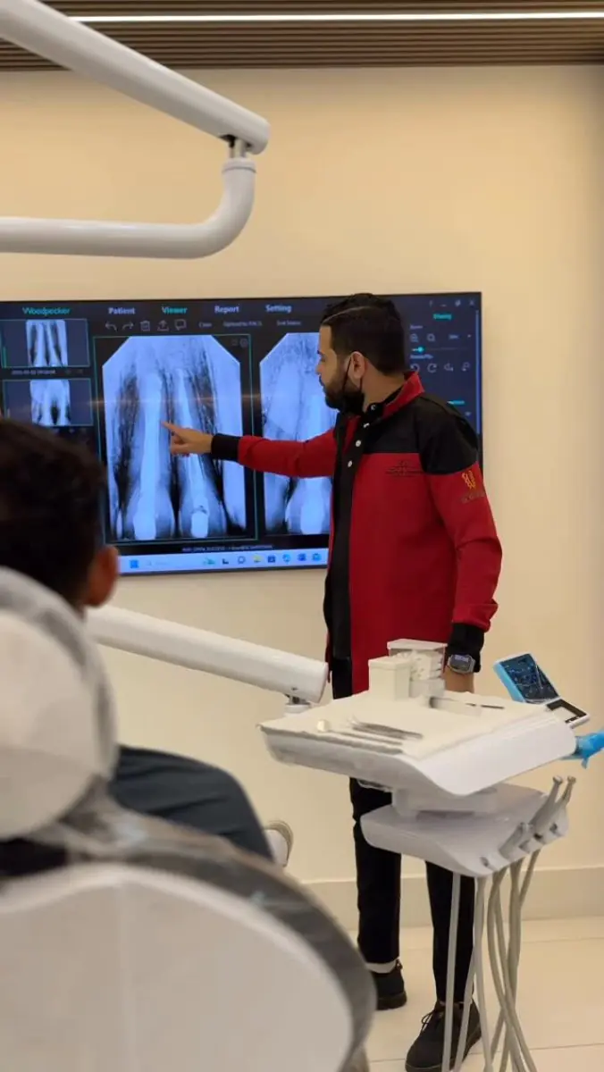 Стоматолог объясняет рентгеновские снимки зубов в кабинете J R Estetica Dental