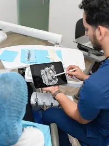 Dentista revisando radiografía dental con paciente en Centro Odontológico Integral Avanzado