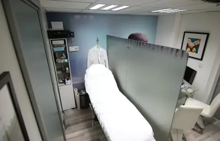 غرفة علاج في عيادة Dr. Rafael Mirabal Batista بسرير طبي وديكور حديث
