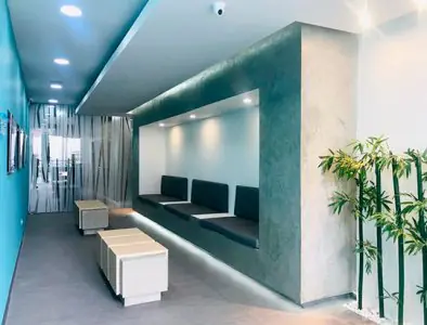 Área de espera moderna en 14-85 Dental Spa con asientos minimalistas y plantas