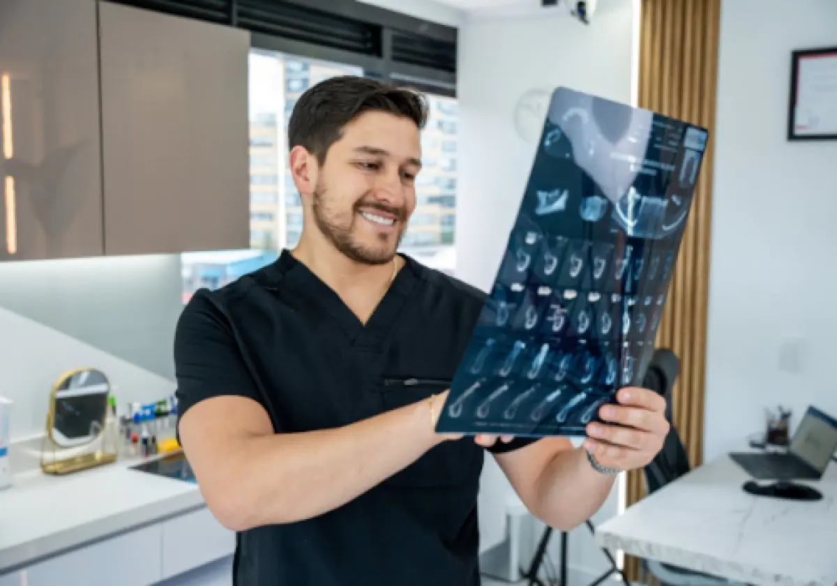 Dentist examining dental X-ray at Elite Smiles clinic modern consultation room