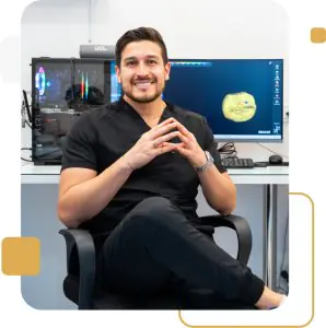 Dentista en la clínica Elite Smiles con software dental CAD en oficina moderna