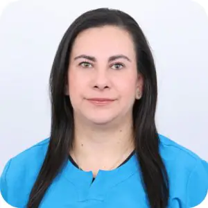 Miembro del personal dental con uniforme azul en la clínica Elite Smiles