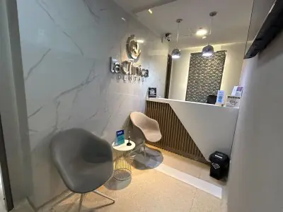Área de recepción en La Clinic Dental Colombia con asientos modernos y paredes de mármol