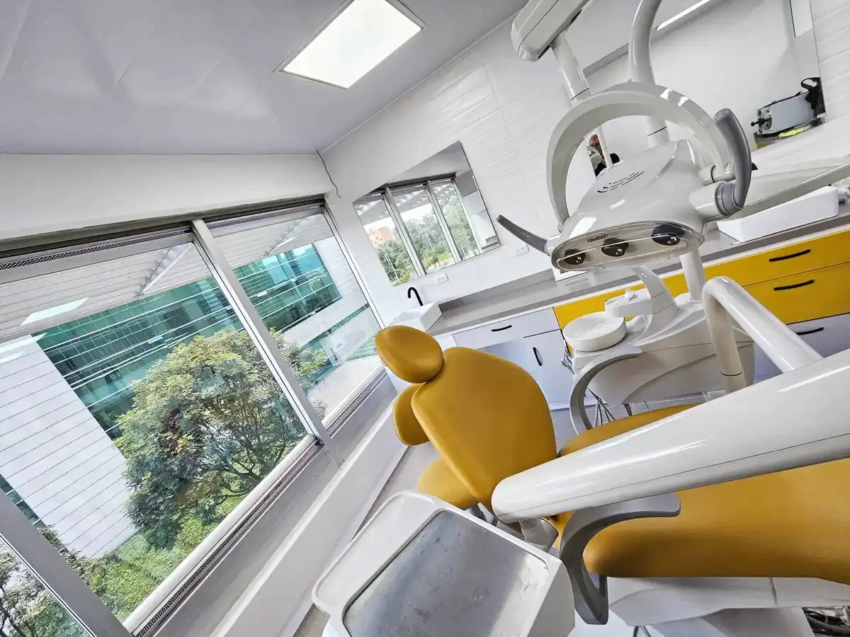 Modern dental treatment room at Dr. Iván Lindo’s Clinic with yellow chair