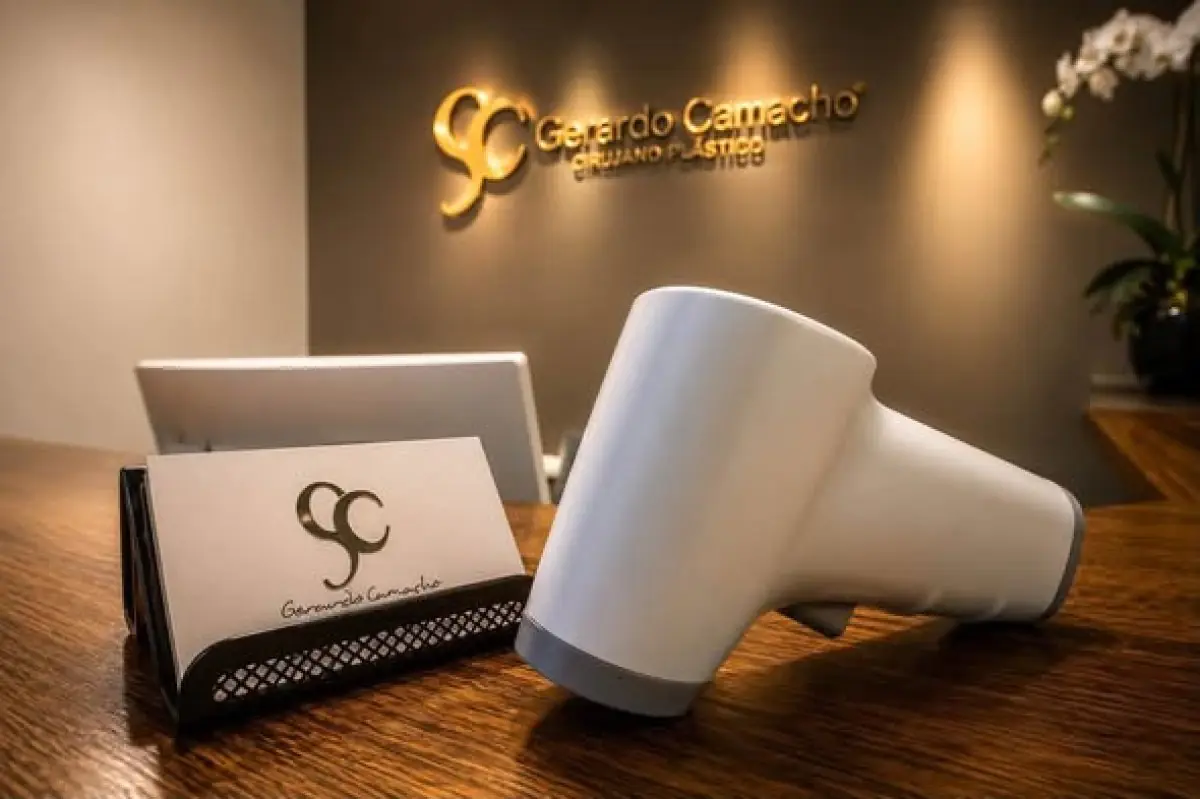 Reception desk at Dr. Gerardo Camacho clinic with medical device and business cards