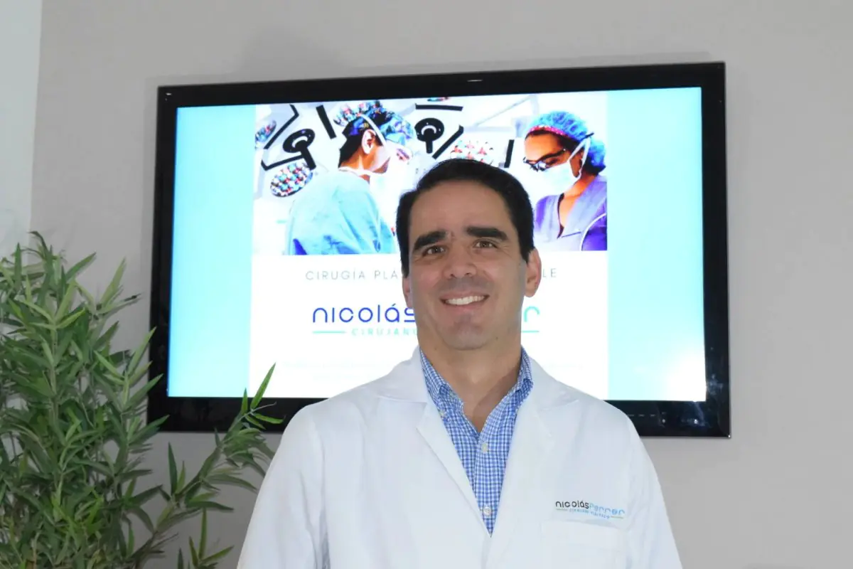 Plastischer Chirurg in der Klinik Dr. Nicolás Ferrer mit medizinischer Präsentation im Hintergrund