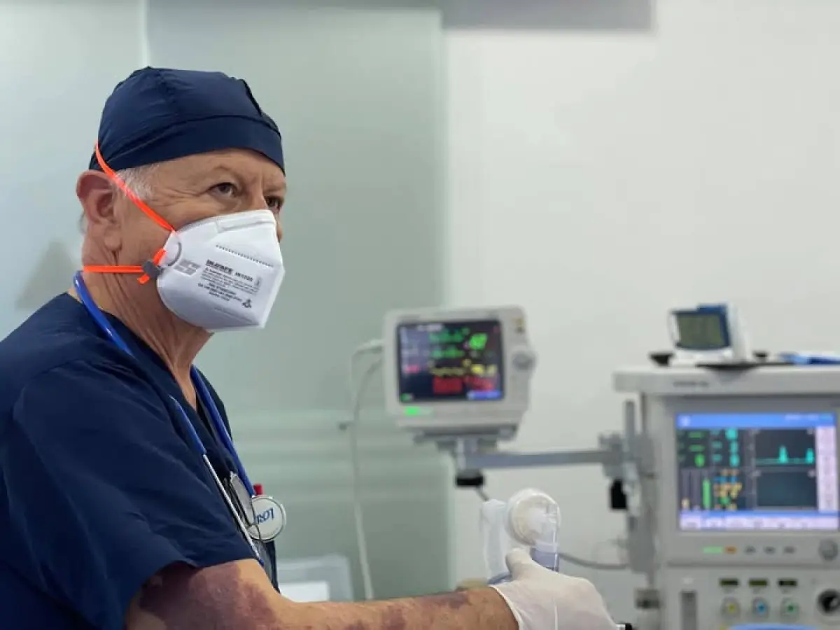 Surgeon in operating room at Dr. Juan Carlos Olaya clinic with advanced monitoring equipment