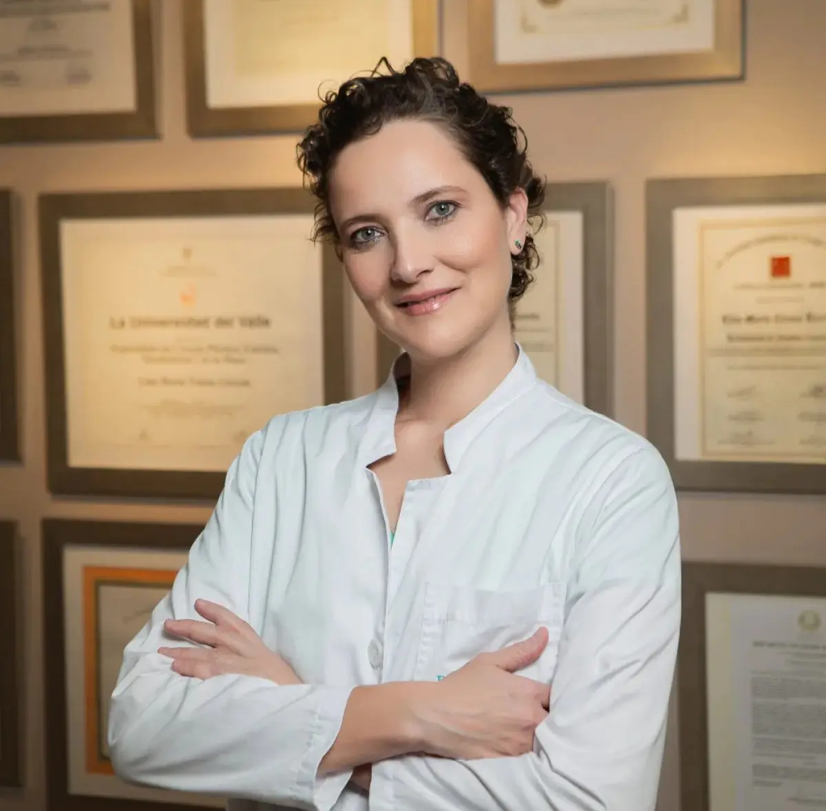 Doctor at Corpus y Rostrum clinic with medical certificates on wall
