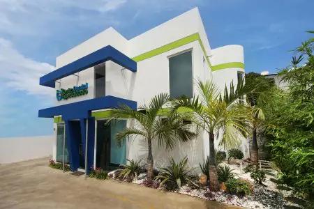 Exterior de la clínica Centro Dental Especializado con fachada moderna y jardinería tropical