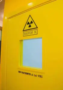 Puerta de sala de rayos X en GO Dental con señal de advertencia de radiación