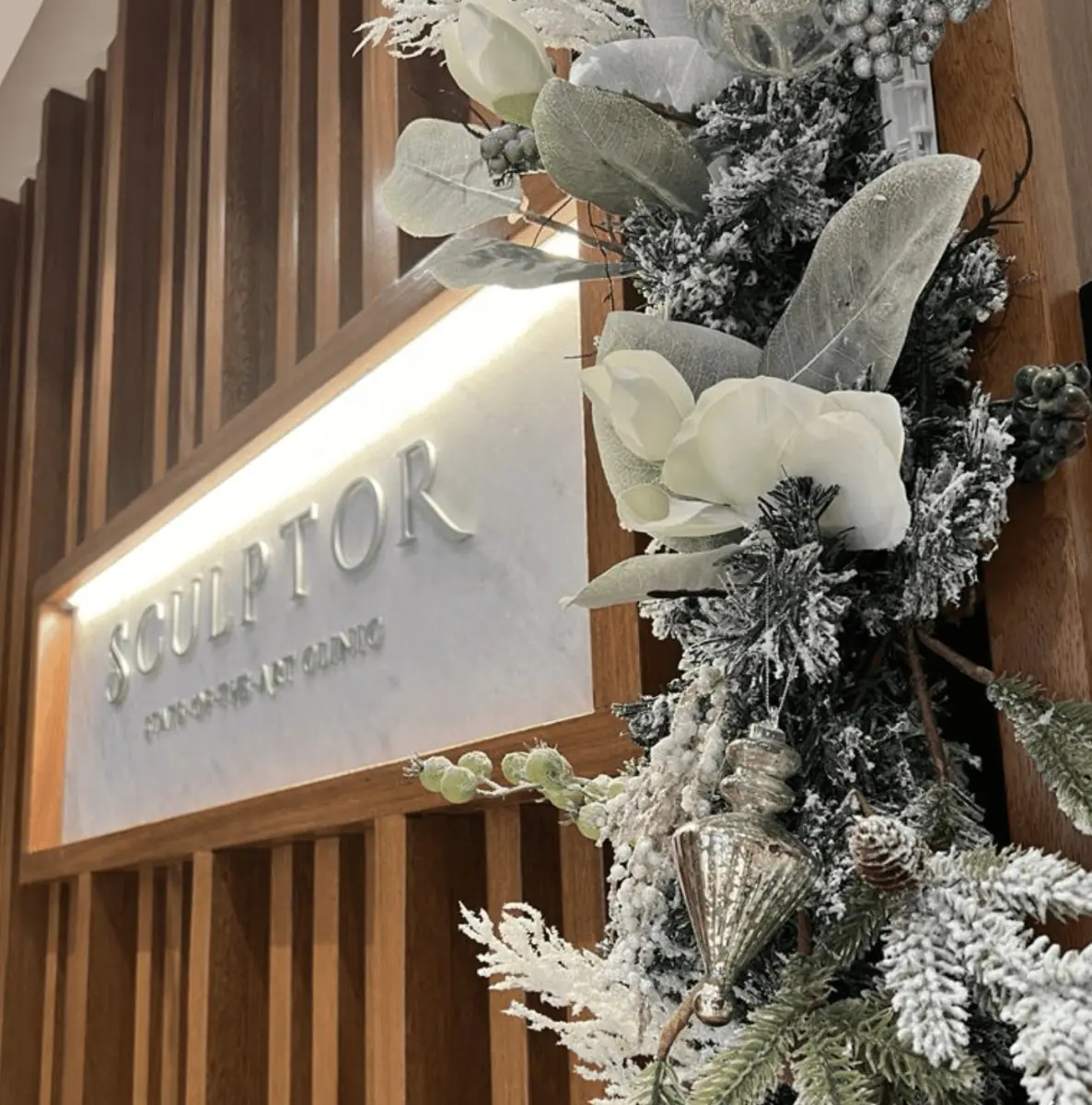 Sculptor Clinic reception sign with festive winter floral decor