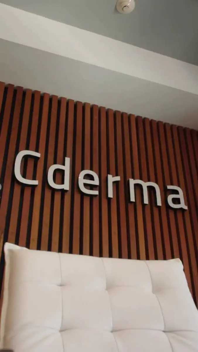 Ściana recepcji kliniki CDERMA z nowoczesnym drewnianym panelem