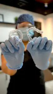 موظف في DentArtist Dental Clinic يحمل تقويم شفاف في غرفة العلاج