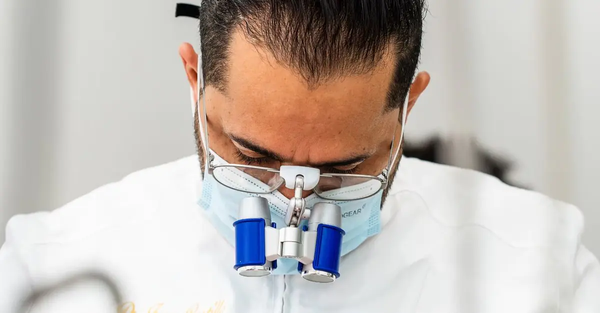 Dentysta z lupami powiększającymi w klinice Dr. Juan Castillo – Handmade Smile