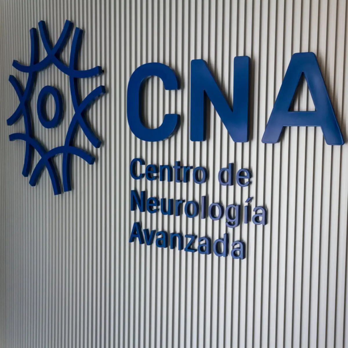Kliniklogo von CNA Centro de Neurología Avanzada an moderner Wand
