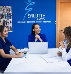 Reunión del personal médico en la recepción de Salutte Clinic, interior azul moderno
